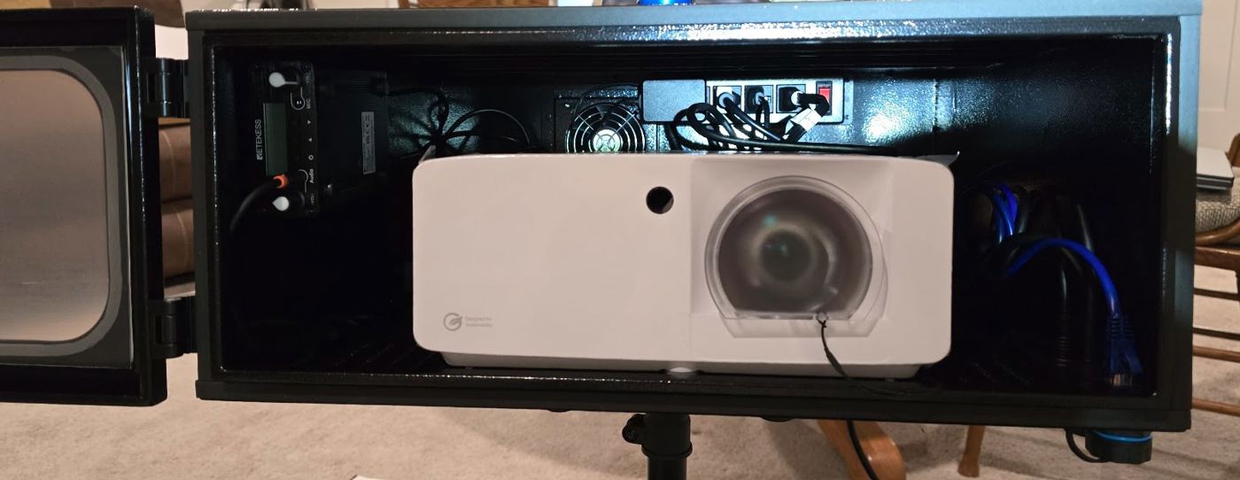 Outdoor projector setup in weatherproof enclosure for house projection mapping